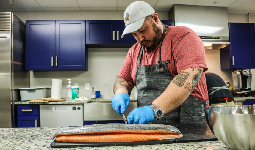 A chef cuts a salmon during a tasting