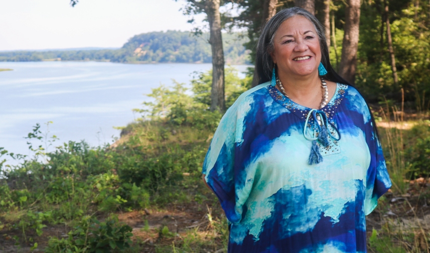 Chief Ann Richardson of the Rappahannock Tribe poses in front of a body of water and trees