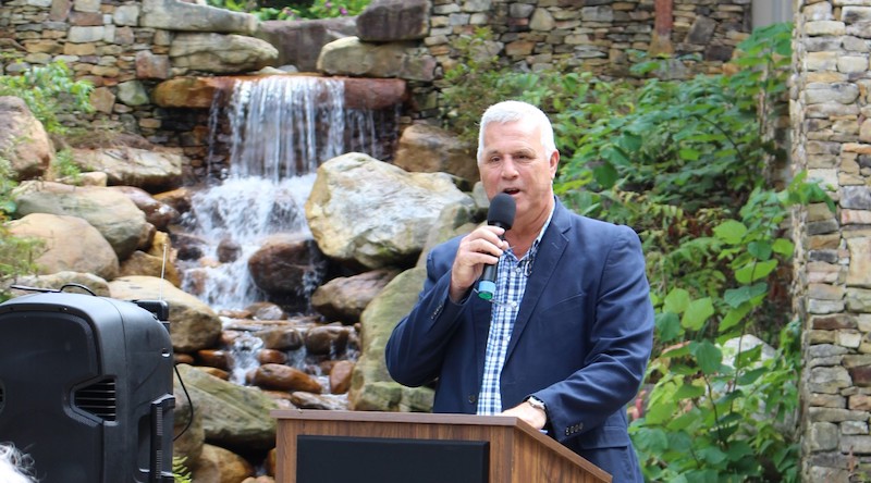 Man holding a microphone and speaking