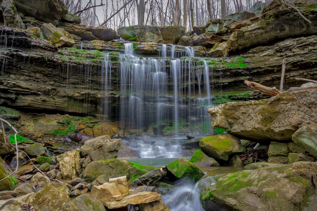 Waterfall over rock face with green moss