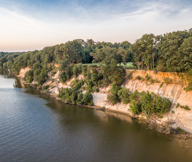 Cliffside along a river with trees