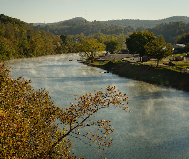 River with mist rising from the water and trees along the river bank