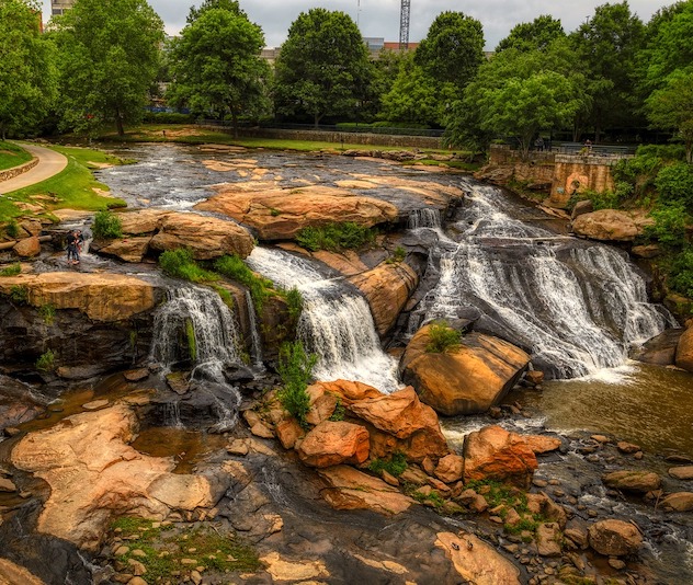 Rocks and waterfall in a park with leafy trees