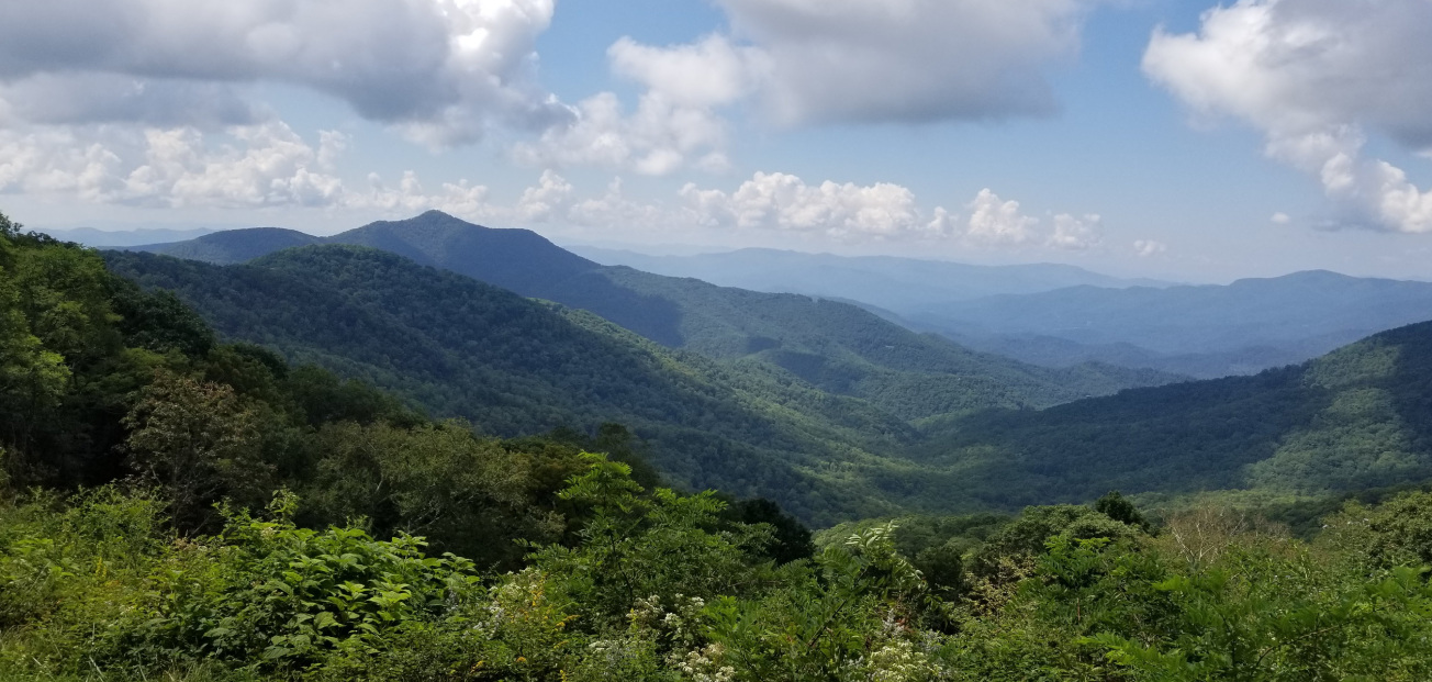 Panoramic view of Balsam Gap, North Carolina, with rolling hills and mountain ranges in the distance.